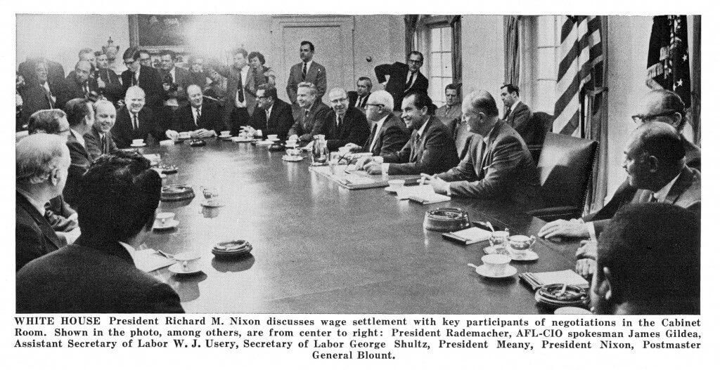 Caption reads: WHITE HOUSE President Richard M. Nixon discusses wage settlement with key participants of negotiations in the Cabinet Room. Shown in the photo, among others, are from center to right: President Rademacher, AFL-CIO spokesman James Gides, Assistant Secretary of Labor W.J. Usery, Secretary of Labor George Shultz, President Meany, President Nixon, Postmaster General Blount