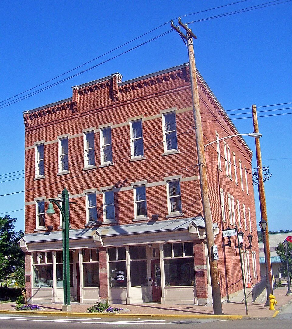 Pictured is a large, three story brick building.